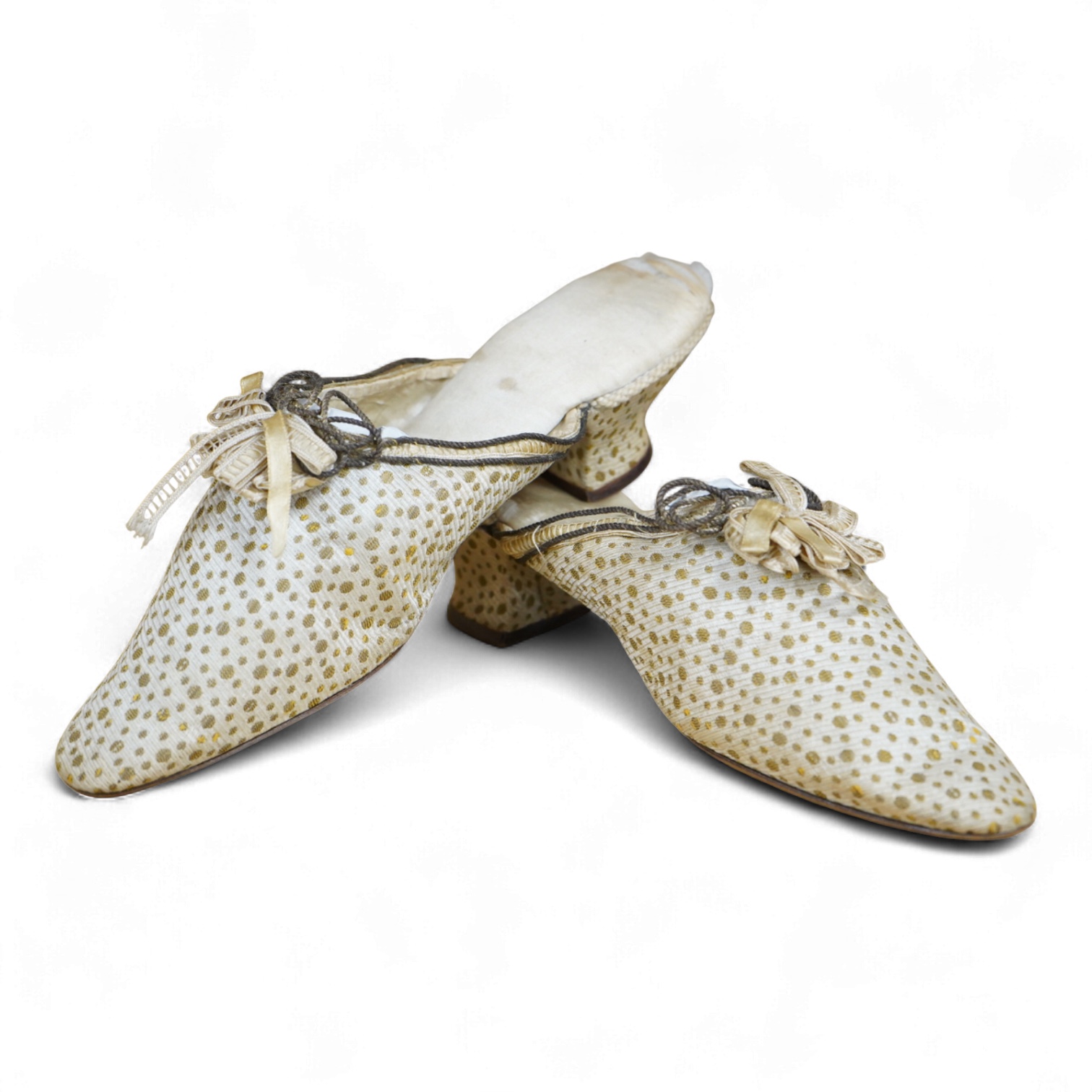 Of interest to collectors and costume designers: a pair of late 19th / early 20th century ladies gold spot embroidered mules, decorated at the front with a rosette of silk ribboning and fine cording. Condition - the cord